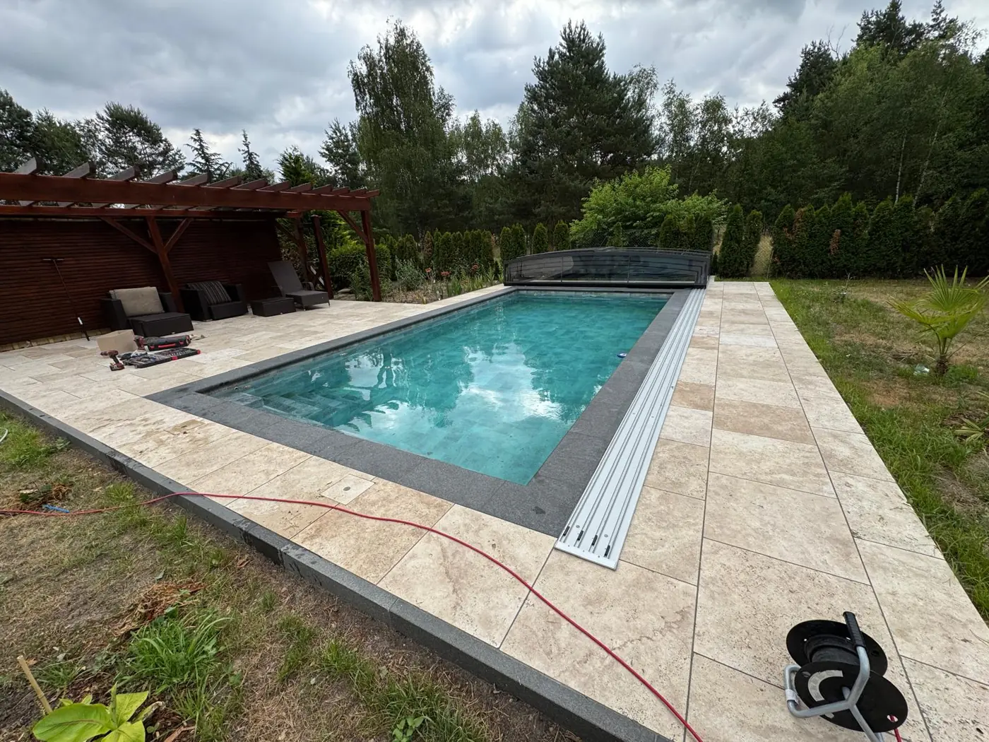 Außenpool mit Abdeckung und Natursteinplattform